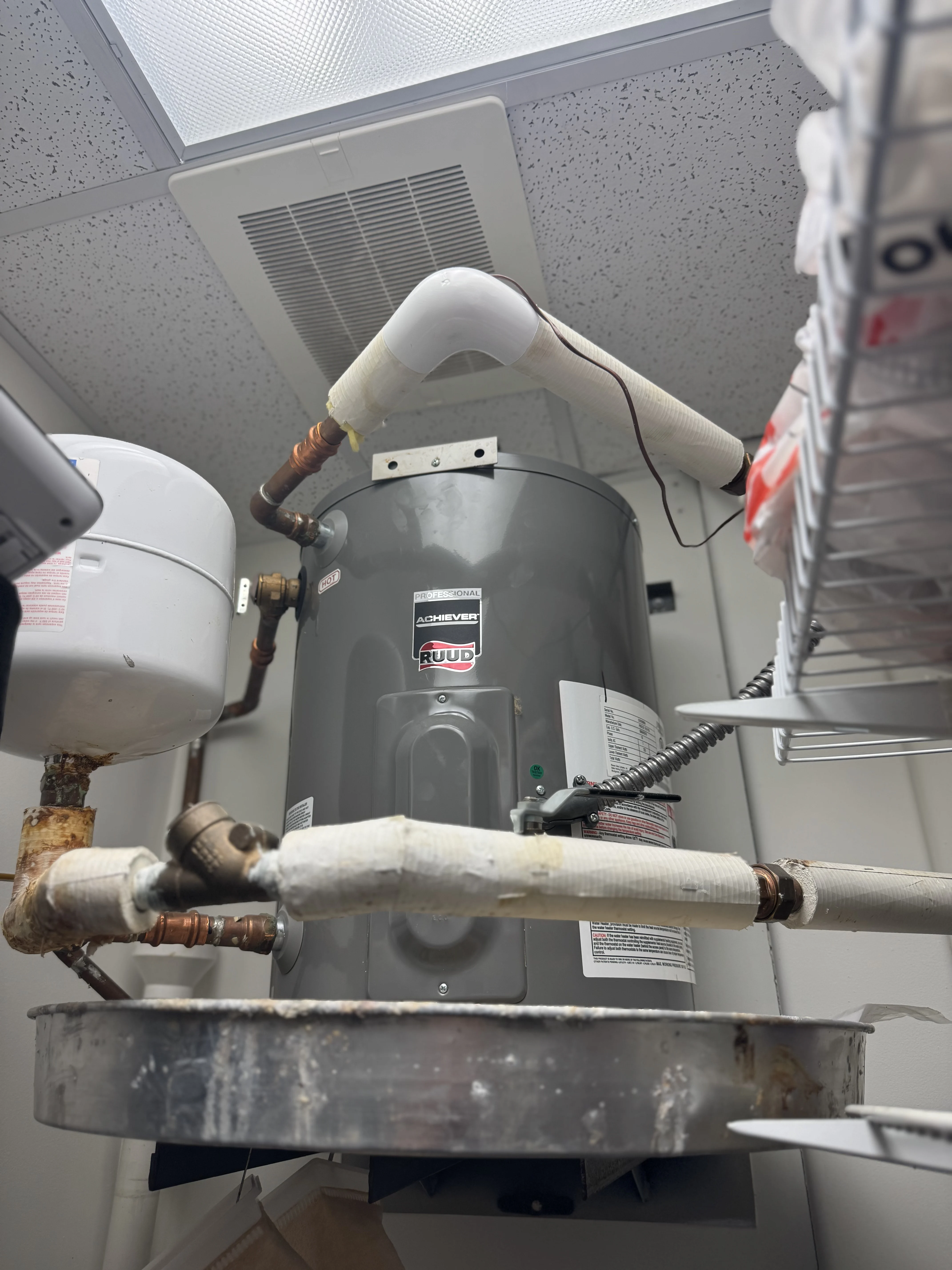 Commercial-style electric water heater with insulated pipe fittings and expansion tank