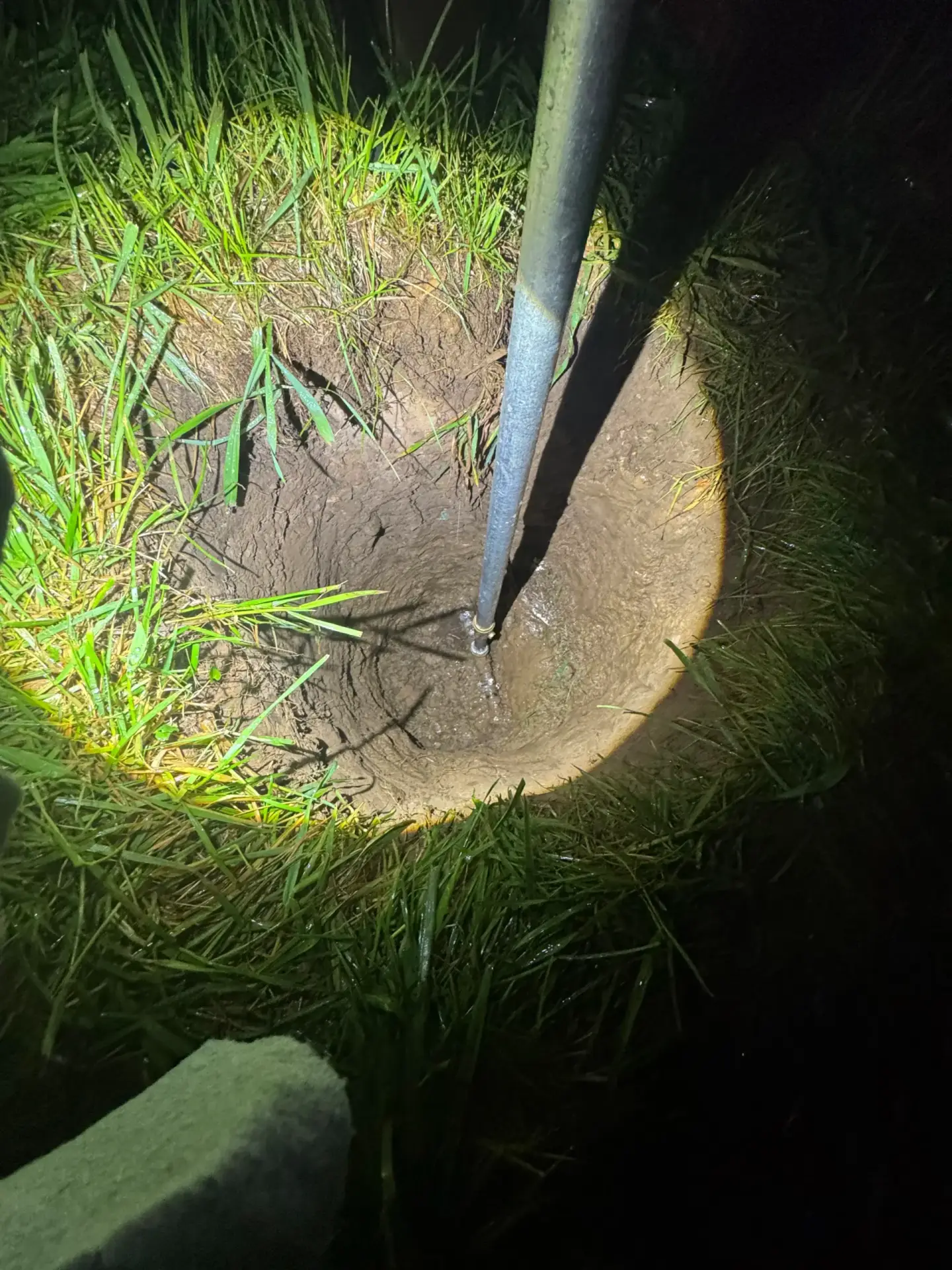 Tools and exposed pipe during a nighttime emergency plumbing repair