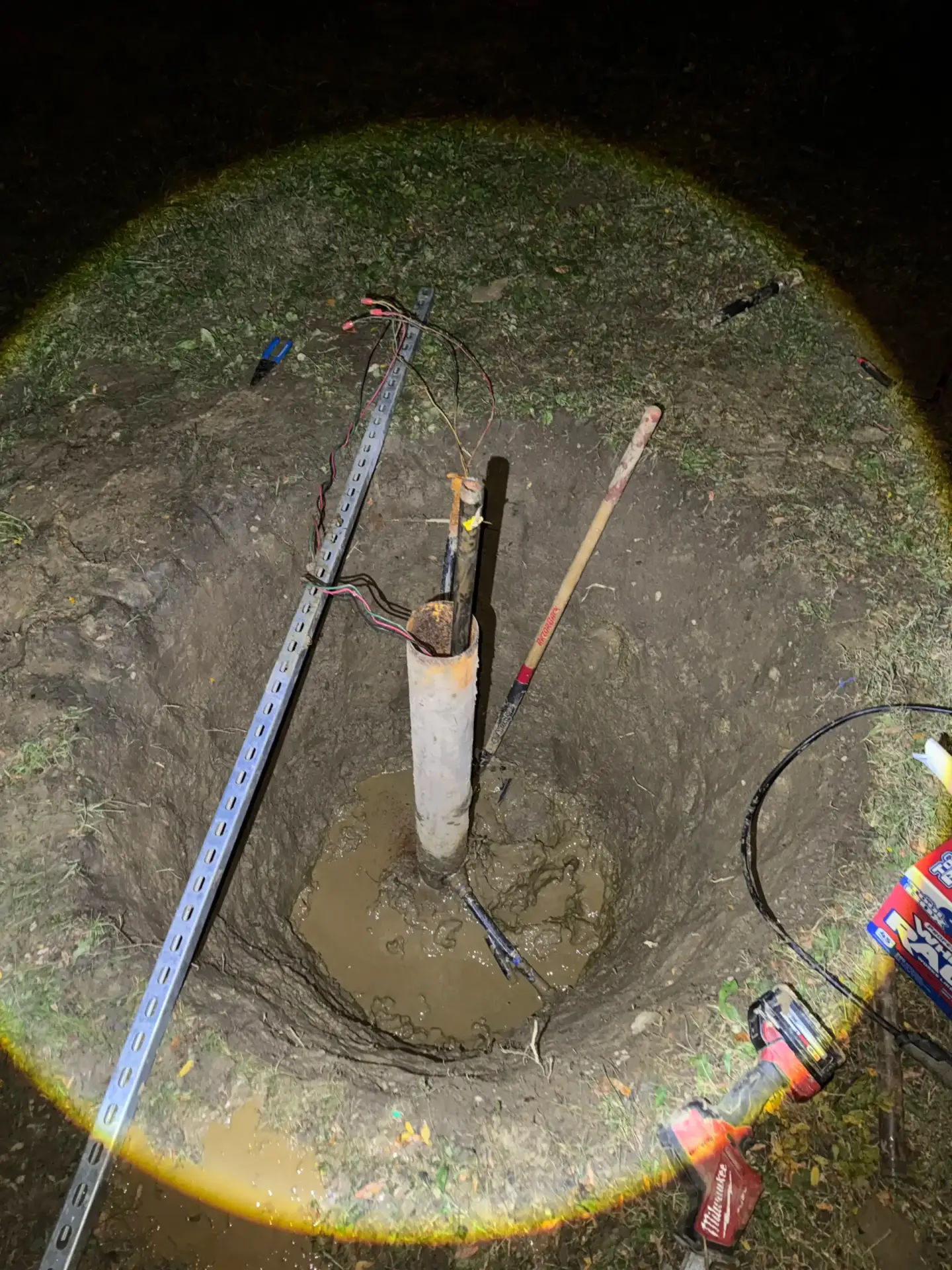 Emergency plumbing repair in progress with an exposed pipe and standing water
