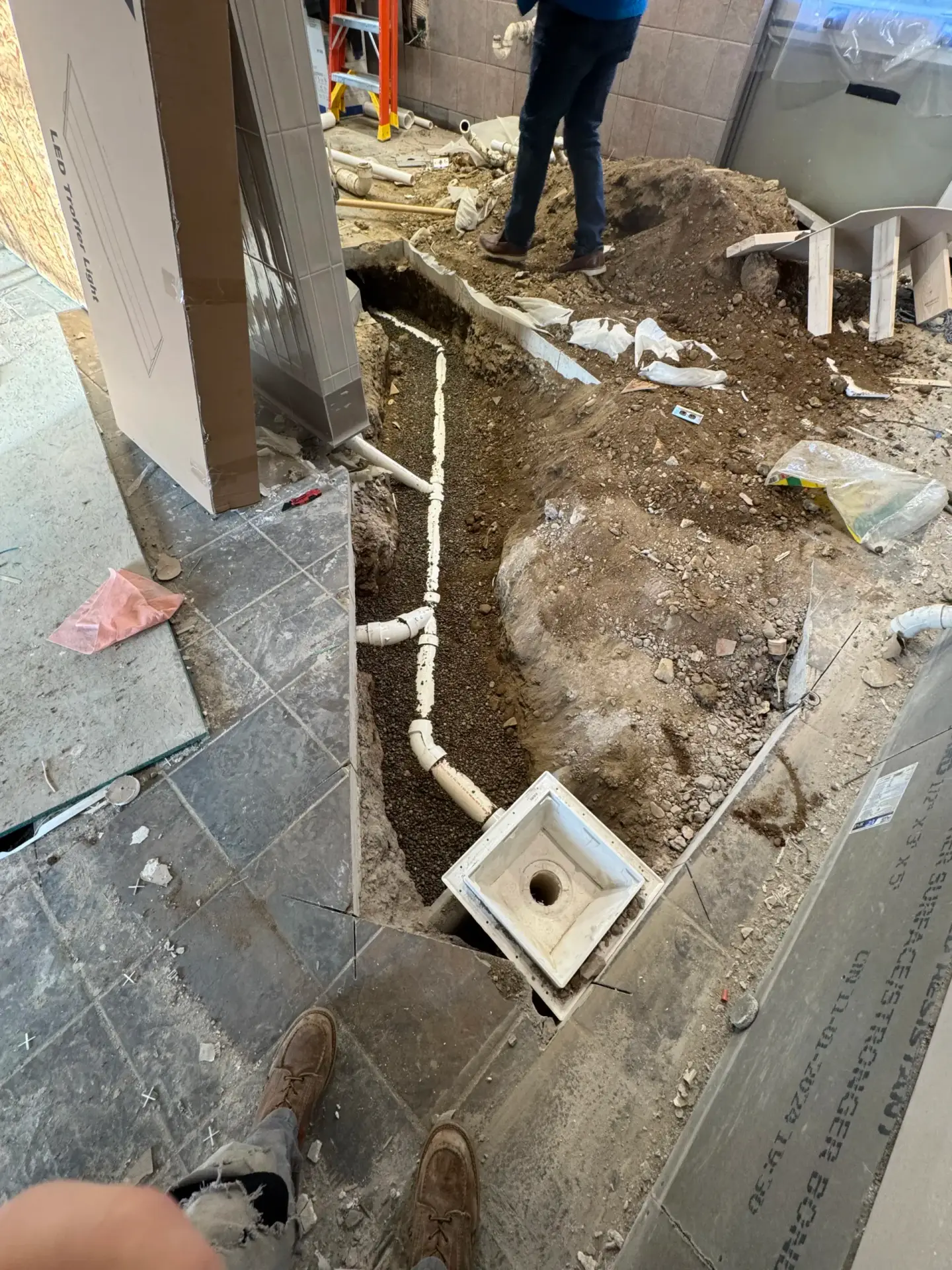 Open trench showing a new sewer pipe and cleanout access during a repair